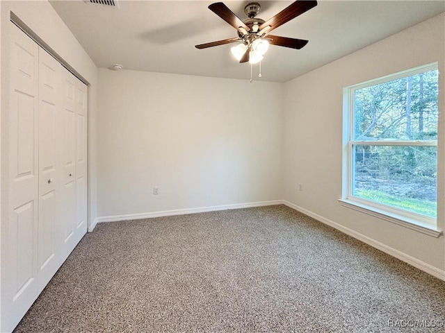 unfurnished bedroom with visible vents, baseboards, a ceiling fan, carpet, and a closet