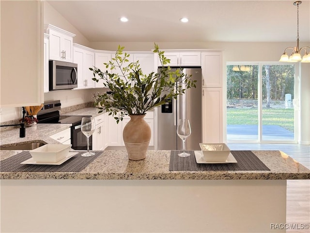 1370 SW Obee Ridge Rd, Dunnellon, FL 34430 - kitchen featuring stainless steel appliances, light stone counters, white cabinetry, recessed lighting, and hanging light fixtures