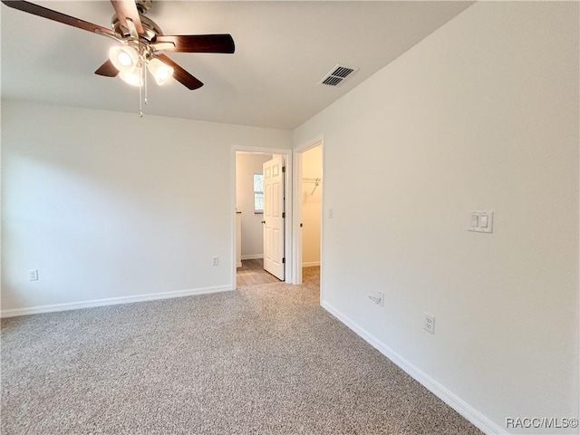 spare room featuring baseboards, visible vents, a ceiling fan, and light colored carpet