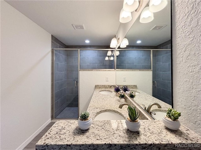 full bath featuring a stall shower, visible vents, and a sink