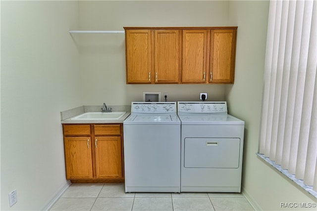 laundry area featuring washer and clothes dryer, cabinets, light tile patterned floors, and sink