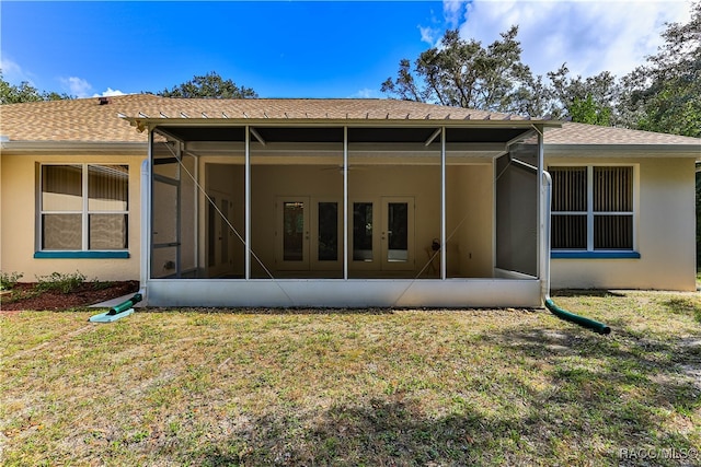 rear view of property featuring a lawn and french doors