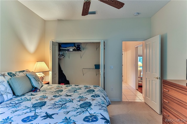 bedroom featuring light carpet, a closet, and ceiling fan