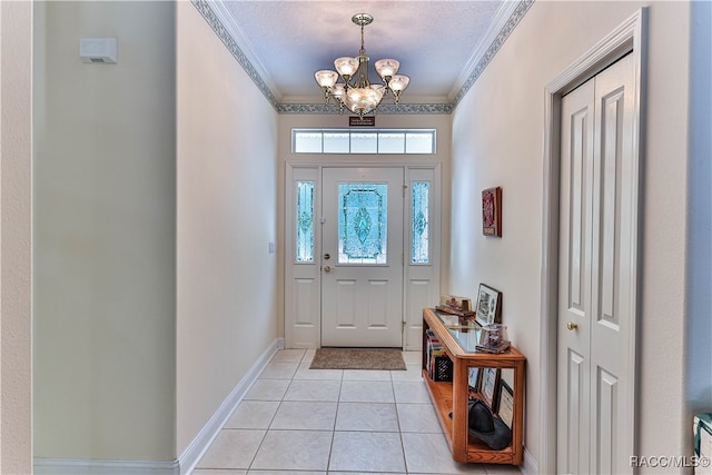 foyer entrance featuring a notable chandelier, crown molding, light tile patterned floors, and a textured ceiling