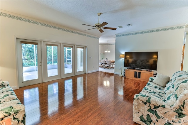 living room with dark hardwood / wood-style floors, a textured ceiling, ceiling fan with notable chandelier, and french doors