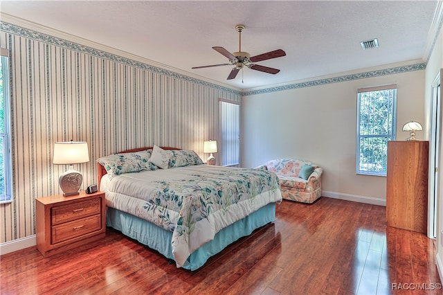 bedroom with ceiling fan, dark wood-type flooring, a textured ceiling, and ornamental molding