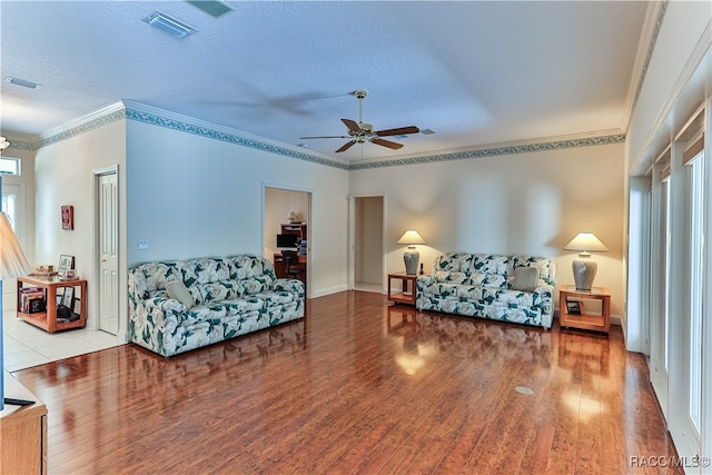 living room featuring a textured ceiling, ceiling fan, crown molding, and light hardwood / wood-style flooring