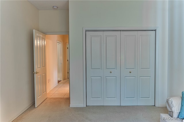 bedroom featuring light carpet and a closet