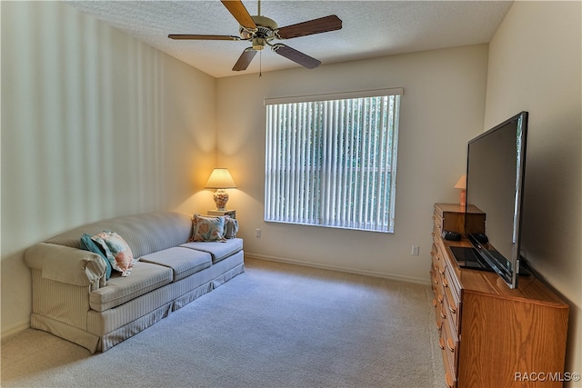 carpeted living room with ceiling fan and a textured ceiling