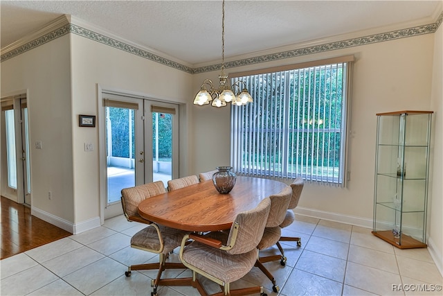 tiled dining room featuring crown molding, french doors, a chandelier, and a textured ceiling