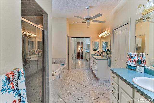 bathroom featuring vanity, a textured ceiling, ceiling fan, tile patterned flooring, and shower with separate bathtub