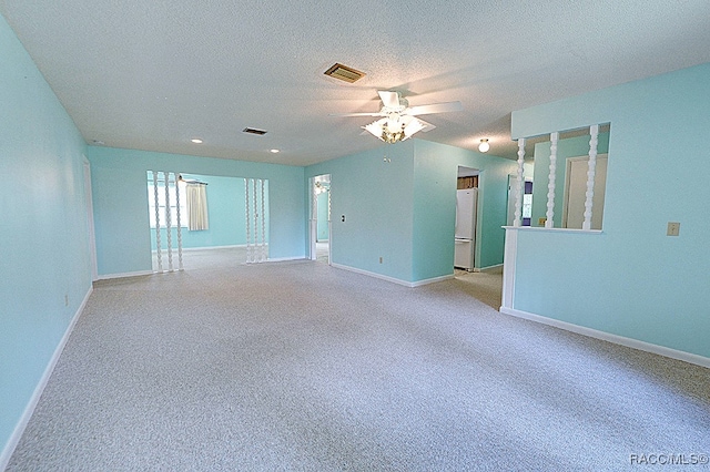 carpeted empty room featuring ceiling fan and a textured ceiling