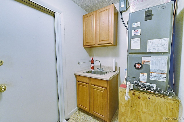 kitchen with sink, a textured ceiling, and heating unit