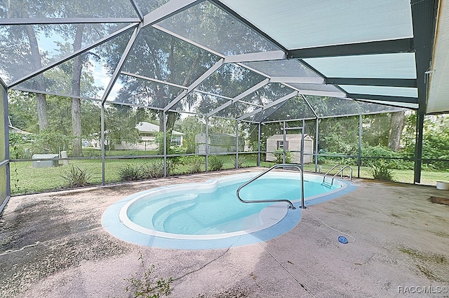 view of swimming pool with a patio, a storage unit, and a lanai