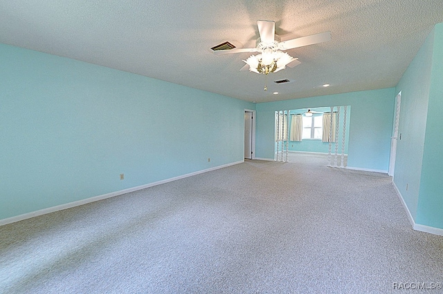 carpeted empty room with ceiling fan and a textured ceiling