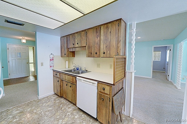 kitchen with white dishwasher, tasteful backsplash, light colored carpet, and sink