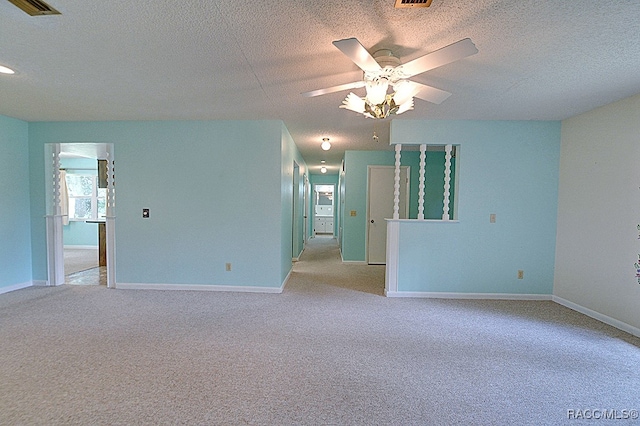 spare room with light carpet, ceiling fan, and a textured ceiling