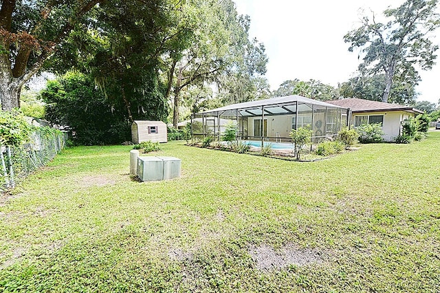 view of yard with a shed and a lanai