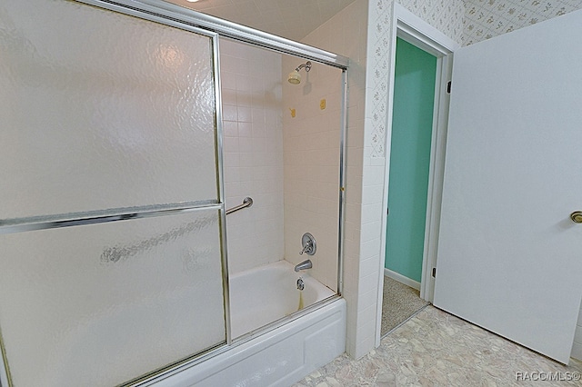 bathroom featuring bath / shower combo with glass door