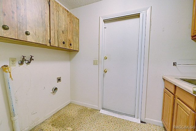 laundry area featuring cabinets, a textured ceiling, and electric dryer hookup