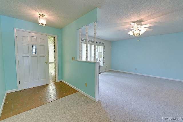 foyer entrance featuring carpet, a textured ceiling, and ceiling fan