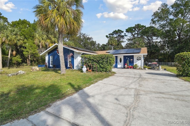 single story home featuring a front yard and solar panels