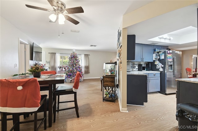 kitchen with stainless steel fridge with ice dispenser, light wood-type flooring, and ceiling fan