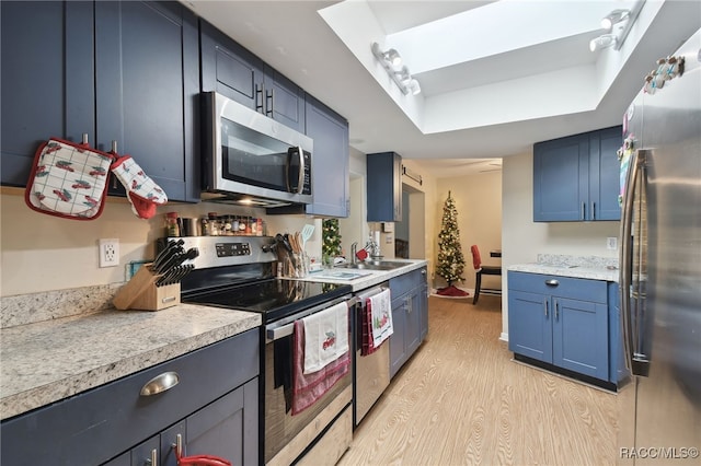 kitchen with sink, blue cabinets, stainless steel appliances, and light hardwood / wood-style flooring