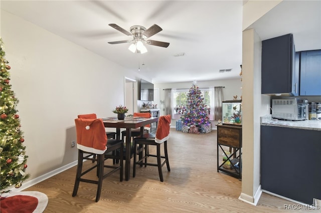 dining area with ceiling fan and light hardwood / wood-style floors