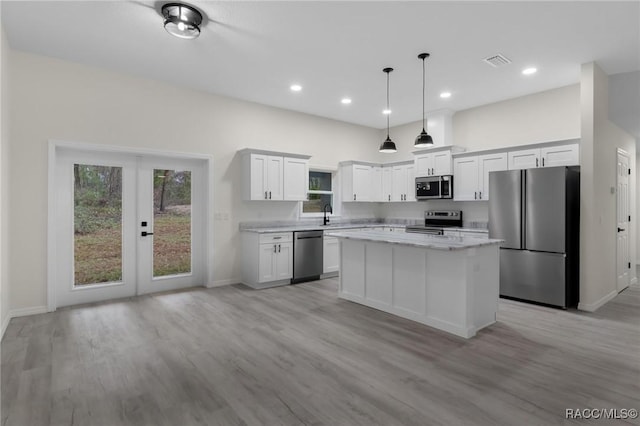 4911 S Skyblue Dr, Inverness, FL 34452 - kitchen with a kitchen island, white cabinetry, visible vents, appliances with stainless steel finishes, and pendant lighting