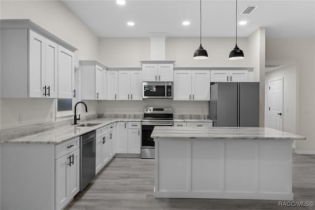 4911 S Skyblue Dr, Inverness, FL 34452 - kitchen with stainless steel appliances, white cabinetry, a sink, and a kitchen island