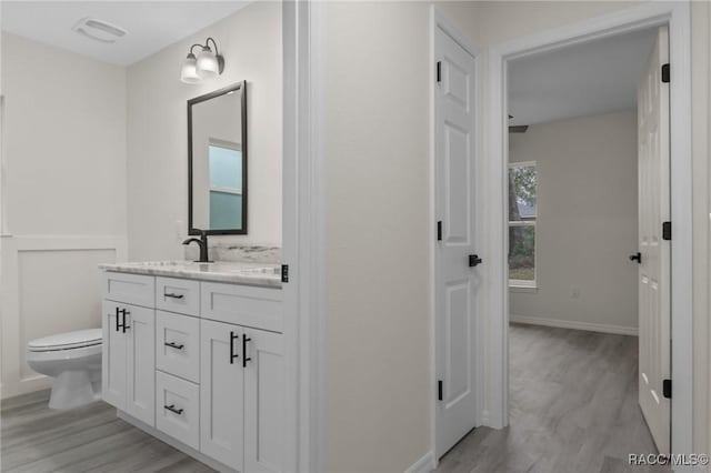 4911 S Skyblue Dr, Inverness, FL 34452 - bathroom with baseboards, visible vents, toilet, wood finished floors, and vanity