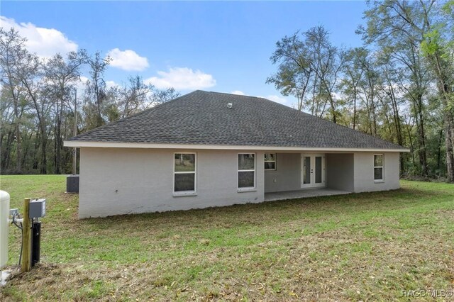 4911 S Skyblue Dr, Inverness, FL 34452 - back of house with roof with shingles, french doors, a lawn, and stucco siding