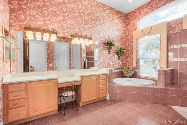 bathroom with tile patterned floors, tiled tub, and vanity