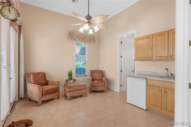 kitchen featuring ceiling fan, light brown cabinets, sink, white dishwasher, and light tile patterned floors