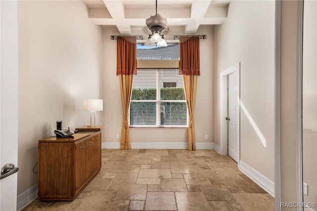 doorway with ceiling fan, beam ceiling, and coffered ceiling