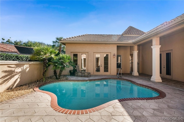 view of swimming pool featuring a patio area and french doors