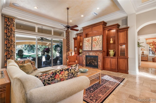 living room featuring a fireplace, a high ceiling, and ornamental molding