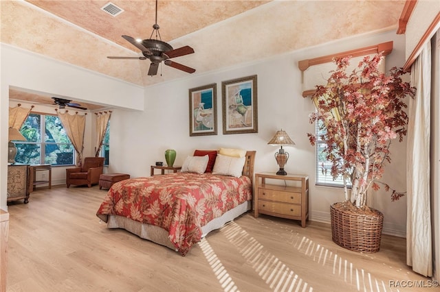 bedroom with hardwood / wood-style flooring, ceiling fan, and ornamental molding