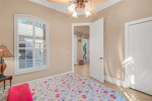 bedroom with a closet, ceiling fan, crown molding, and light tile patterned floors