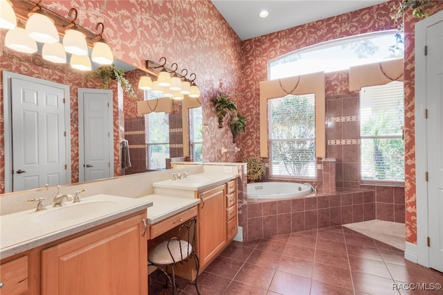 bathroom featuring tile patterned flooring, vanity, plenty of natural light, and tiled tub