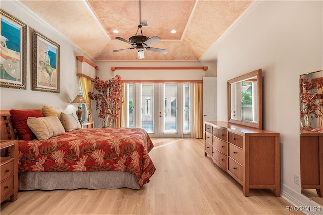 bedroom with access to outside, ceiling fan, light wood-type flooring, ornamental molding, and a tray ceiling