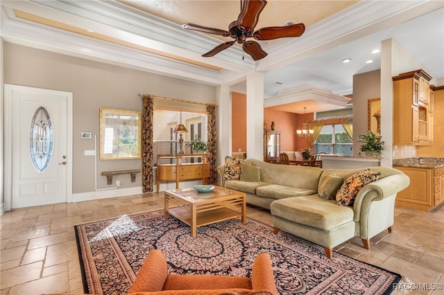 living room featuring a tray ceiling, ceiling fan, and crown molding