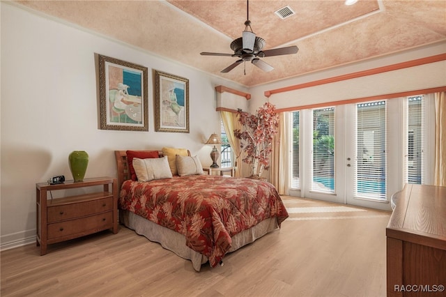 bedroom with ceiling fan, access to exterior, light wood-type flooring, and french doors