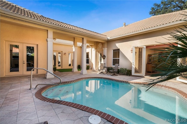 view of pool with french doors and a patio area