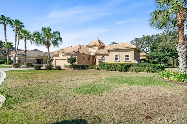 mediterranean / spanish-style house featuring a garage and a front yard