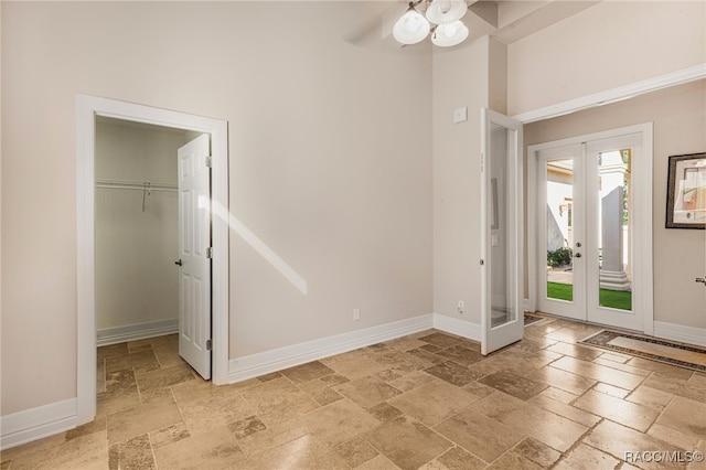 interior space featuring ceiling fan, french doors, and a high ceiling