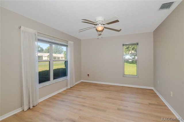 empty room with ceiling fan and light hardwood / wood-style floors