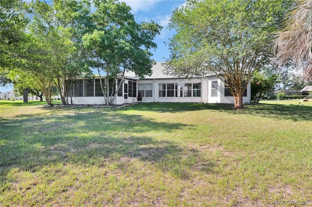 back of house with a yard and a sunroom