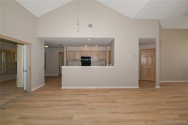 unfurnished living room with high vaulted ceiling and light hardwood / wood-style flooring